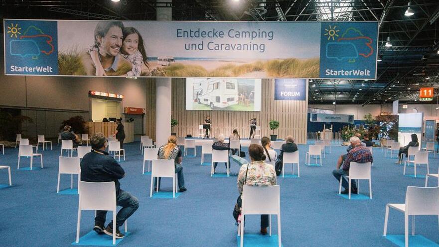 人們在德國杜塞爾多夫房車展上保持社交距離觀看介紹房車的演講。