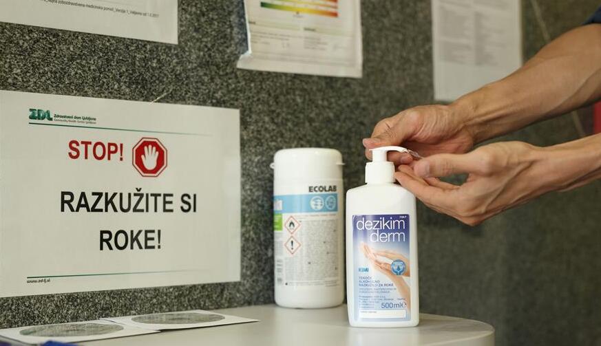 一名男子在斯洛文尼亞盧布爾雅那社區衛生中心牙科門診入口處使用消毒洗手液。
