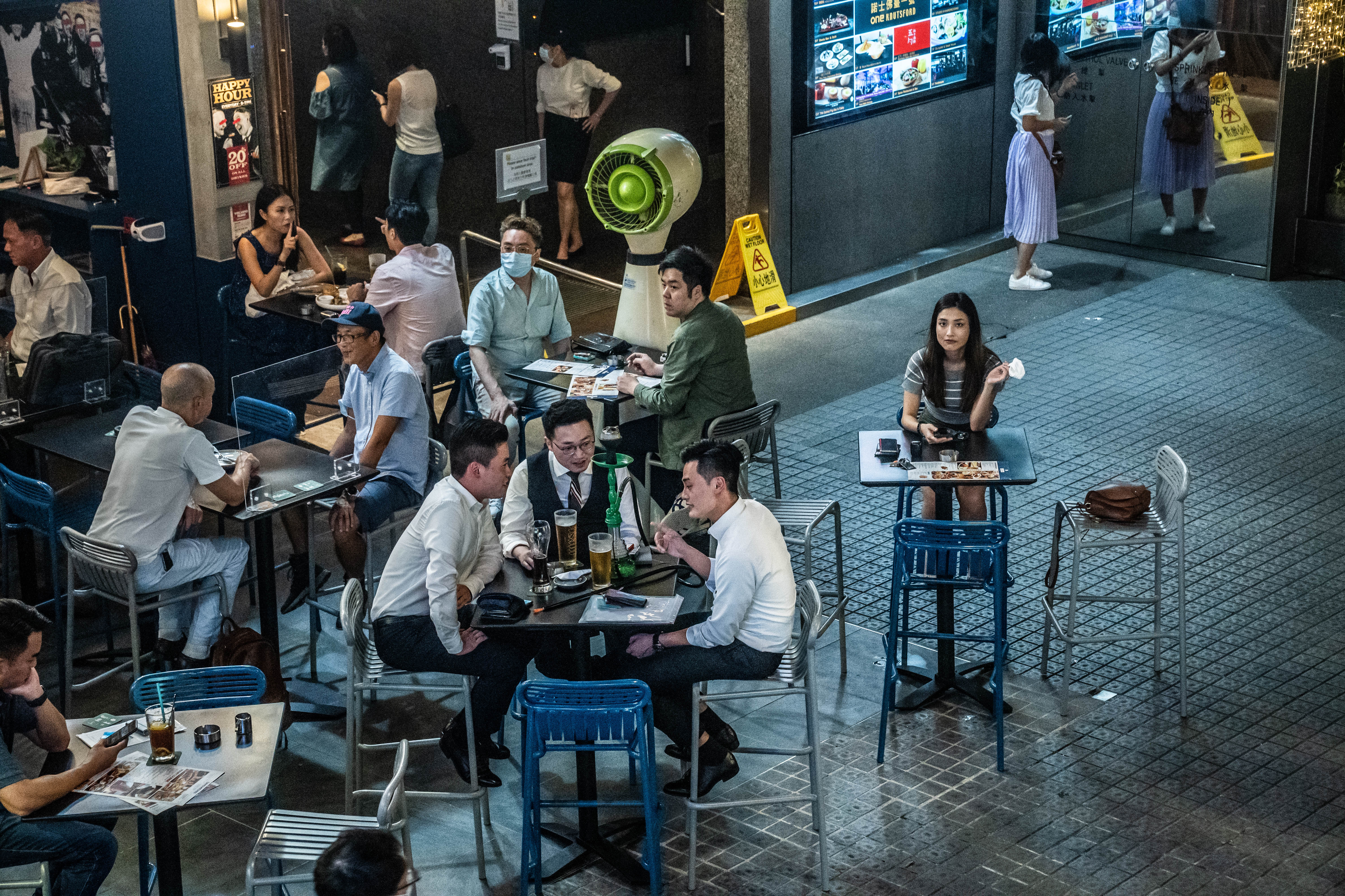 政府昨日放寬部分防疫措施,食肆容許每檯食客增至四人,遊戲機中心及遊樂場所等處所獲准重開。戴著口罩的市民紛紛出街探食。(彭博社) 政府昨日放寬部分防疫措施,食肆容許每檯食客增至四人,遊戲機中心及遊樂場所等處所獲准重開。戴著口罩的市民紛紛出街探食。(彭博社)
