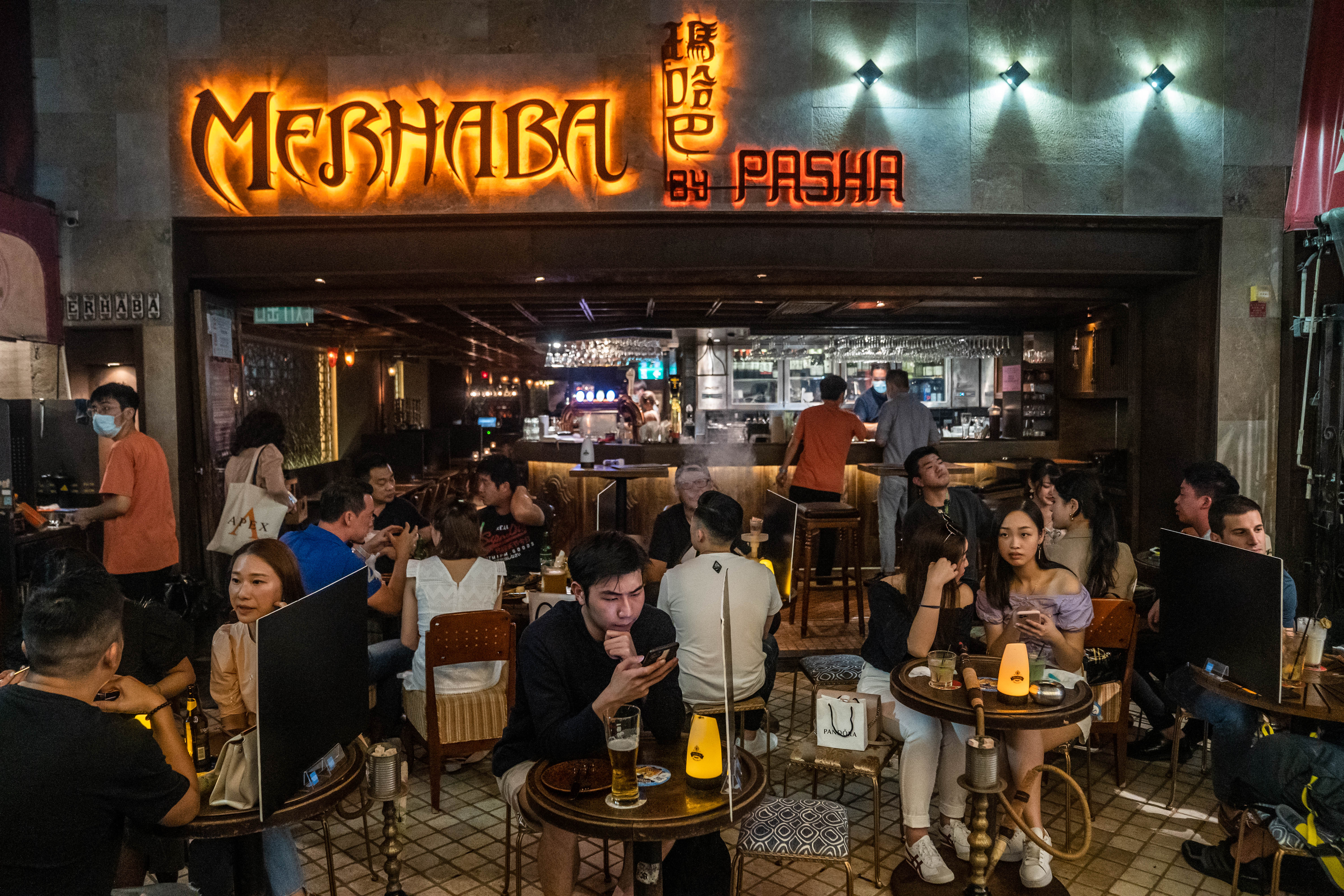 政府昨日放寬部分防疫措施,食肆容許每檯食客增至四人,遊戲機中心及遊樂場所等處所獲准重開。戴著口罩的市民紛紛出街探食。(彭博社) 政府昨日放寬部分防疫措施,食肆容許每檯食客增至四人,遊戲機中心及遊樂場所等處所獲准重開。戴著口罩的市民紛紛出街探食。(彭博社)