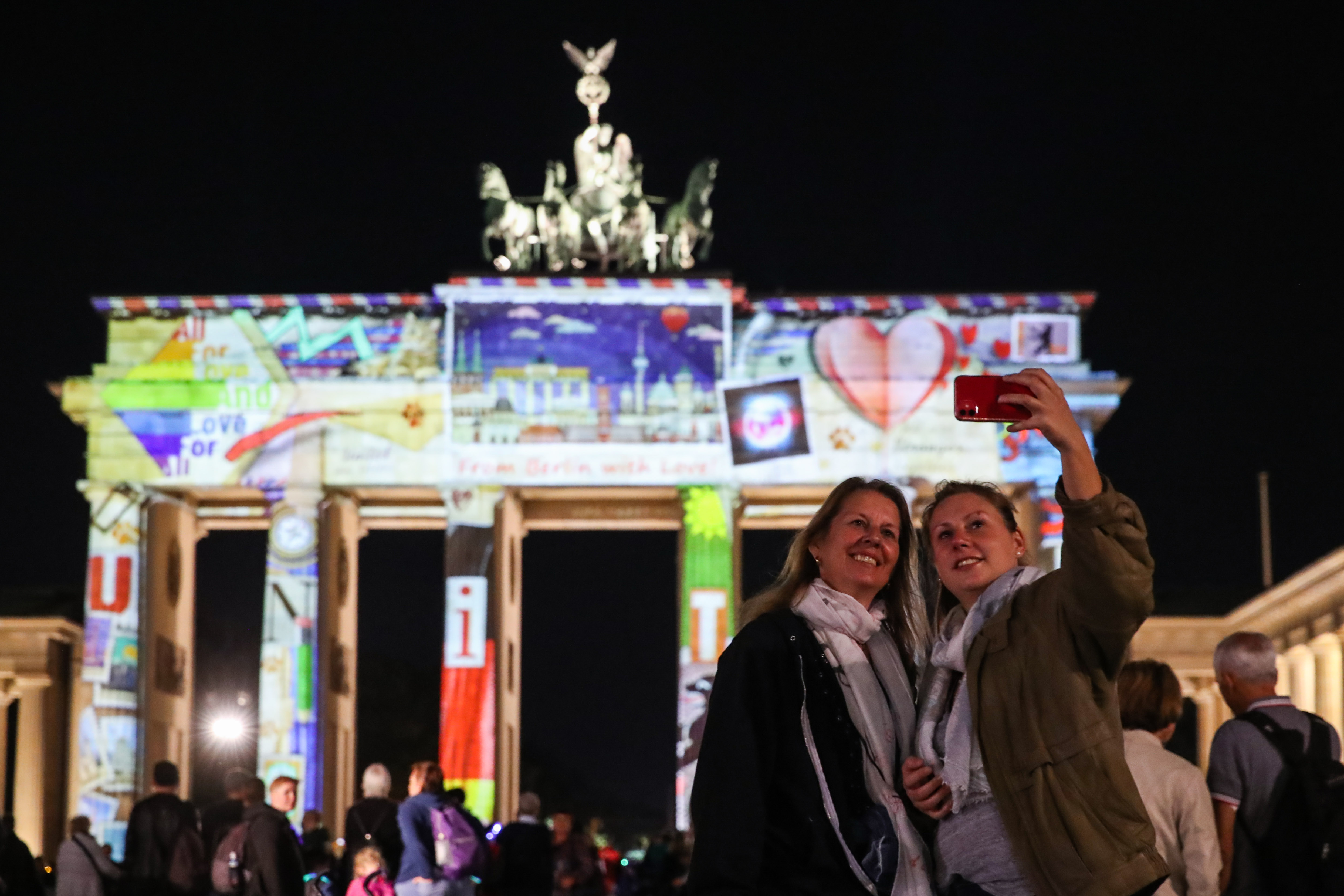 9月11日，在德國首都柏林，兩名遊客在被燈光點亮的勃蘭登堡門前自拍。 一年一度的柏林燈光節11日正式開幕，多處地標性建築被燈光點亮。本屆燈光節將持續至9月20日。（新華社記者 單宇琦 攝）