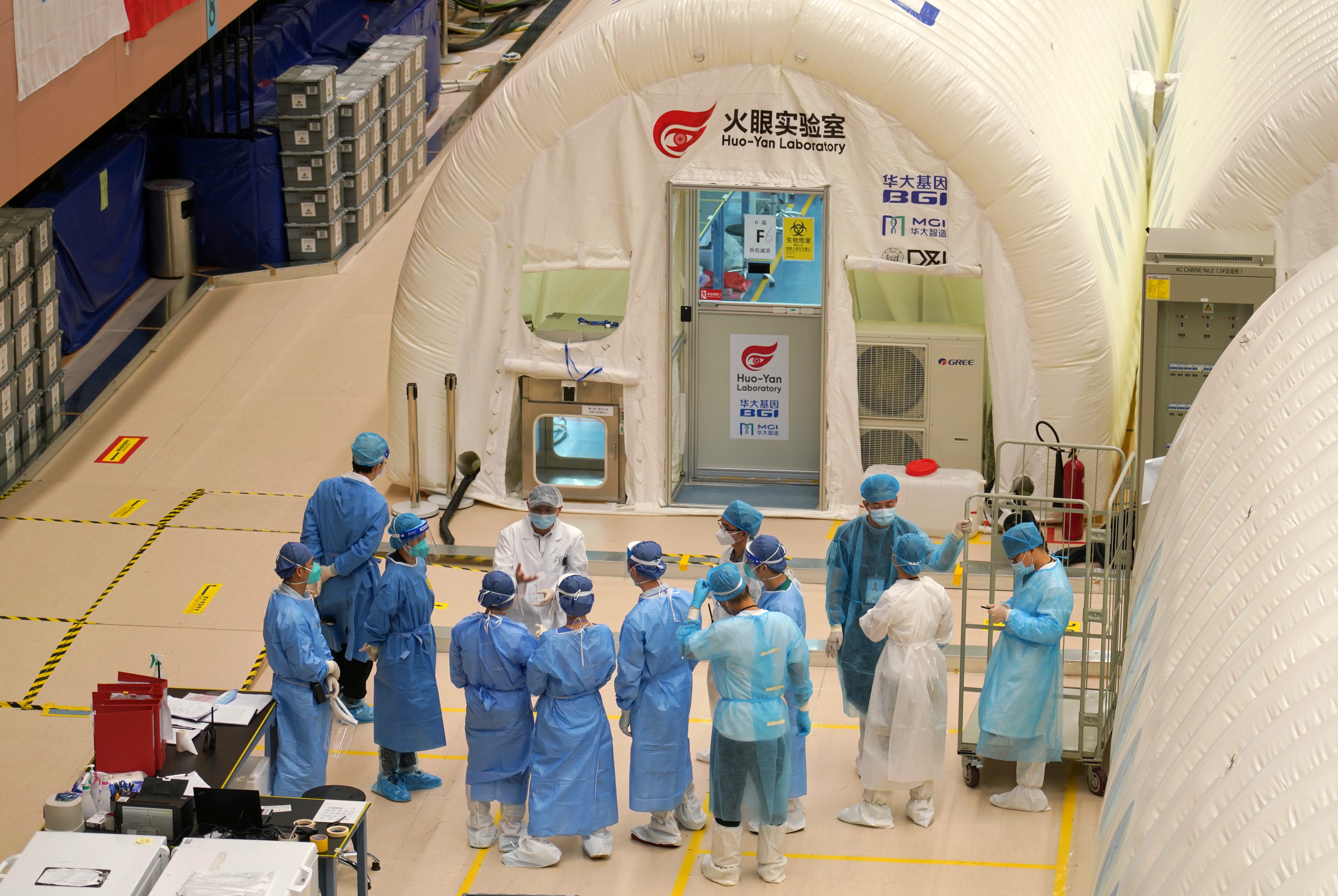 自9月1日開始,香港普及社區檢測計劃實施,所有採集樣本均送到位於香港中山紀念公園體育館的臨時氣膜實驗室(又稱:「火眼實驗室」)進行檢測,經過數百名內地核酸檢測支援隊成員和專業人士夜以繼日的工作,至今已檢測144.8萬個樣本,發現23個樣本呈陽性,為香港抗擊新冠肺炎疫情做出了重要貢獻。圖為輪班上崗的工作人員即將投入工作。(中新社) 自9月1日開始,香港普及社區檢測計劃實施,所有採集樣本均送到位於香港中山紀念公園體育館的臨時氣膜實驗室(又稱:「火眼實驗室」)進行檢測,經過數百名內地核酸檢測支援隊成員和專業人士夜以繼日的工作,至今已檢測144.8萬個樣本,發現23個樣本呈陽性,為香港抗擊新冠肺炎疫情做出了重要貢獻。圖為輪班上崗的工作人員即將投入工作。(中新社)